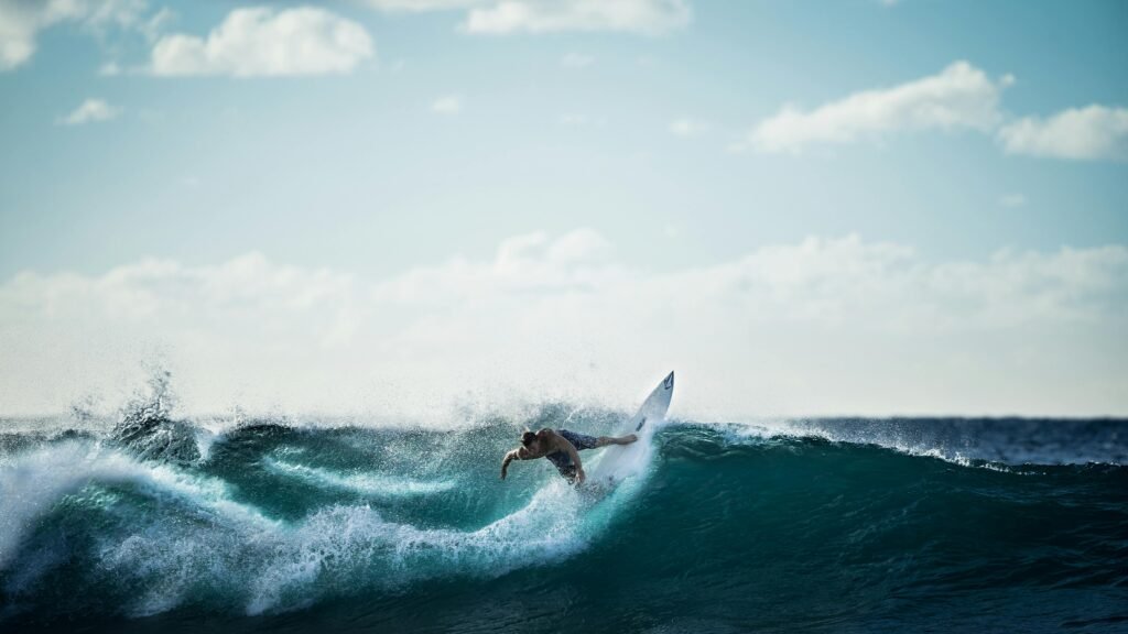 Thrilling action shot of a surfer riding the waves under a clear sky.